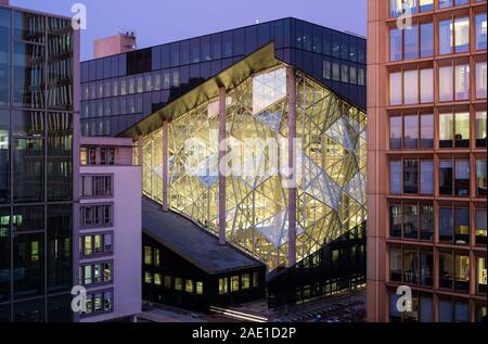 Berlin, Deutschland. 05 Dez, 2019. Die Axel Springer neues Gebäude am Abend in der Dämmerung, von einer Dachterrasse. Auf der linken Seite der Axel-springer-Hochhaus. Nach der Fertigstellung, getöntes Glas Oberflächen und 3D-Elementen wird die Fassade der Licht durchfluteten Büro Gebäude charakterisieren. Eine neue Axel Springer SE Verlagshaus ist errichtet auf dem 10.000 Quadratmeter großen Gelände. Das Gebäude bietet Arbeitsplätze für bis zu 3500 Mitarbeiter. Foto: Jens Kalaene/dpa-Zentralbild/ZB/dpa/Alamy leben Nachrichten Stockfoto