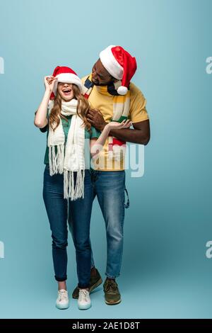 Happy interracial Paare in santa Hüte und Schals Spaß Stockfoto