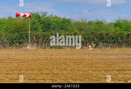 Air Field Richtung unterzeichnen und Windstärke Windsack gegen den dunklen Himmel, von der Start- und Landebahn Stockfoto