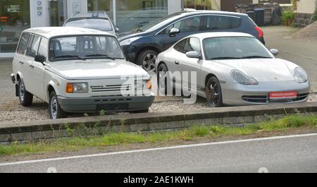 Leipzig, Deutschland. 10 Sep, 2019. Ein Wartburg und ein Porsche stehen Seite an Seite als Gebrauchtwagen im Autohaus in Machern, Sachsen. Credit: Volkmar Heinz/dpa-Zentralbild/ZB/dpa/Alamy leben Nachrichten Stockfoto