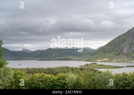 Polarkreis Fjordlandschaft mit grünen Ufern und historischen Boot segeln, unter hellen trübe Licht in der Nähe von Bostad, Lofoten, Norwegen Schuß Stockfoto