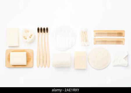 Null Abfall mit natürlichen biologisch abbaubaren Self Care Produkte auf Blau. Bambus Zahnbürsten, handgemachte Seife Shampoo Bars, Wattestäbchen Pads, Hygiene Produkte luffa auf weissem, Ansicht von oben, selektiver Fokus Stockfoto