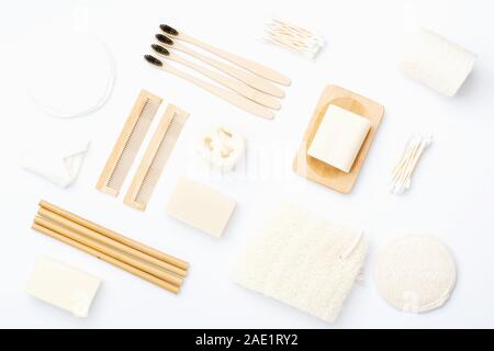Null Abfall mit natürlichen biologisch abbaubaren Self Care Produkte auf Blau. Bambus Zahnbürsten, handgemachte Seife Shampoo Bars, Wattestäbchen Pads, Hygiene Produkte luffa auf weissem, Ansicht von oben, selektiver Fokus Stockfoto