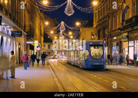 Weihnachtsbeleuchtung auf der Straße in der Nacht, mit der Straßenbahn gestoppt und Verbringung von Personen mit langer Belichtungszeit. Zagreb Kroatien. Stockfoto