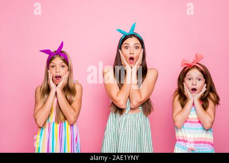 Portrait von beeindruckt Mädchen mit Farbe stirnbänder Schreien omg berühren ihre Wangen Anhörung Nachrichten tragen Kleid Rock über rosa Hintergrund isoliert Stockfoto