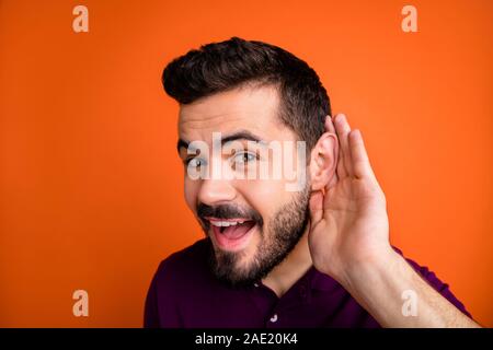 Nahaufnahme Foto von fröhlichen stattlichen interessiert lustige Mann Abhören privater Gespräch neugierig isoliert kräftigen Farbe Hintergrund Stockfoto