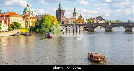 Touristische Fähren Kreuzfahrten auf Moldau und Altstädter Brückenturm, der Karlsbrücke in Prag in der Tschechischen Republik. Stockfoto