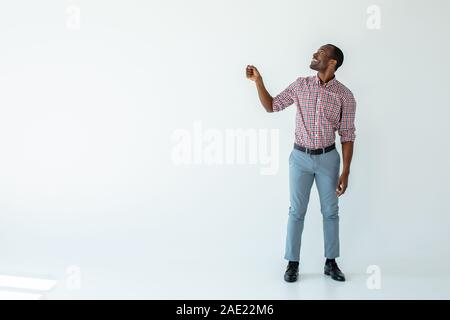 Freudige afro-amerikanische Mann hält einen Regenschirm Stockfoto