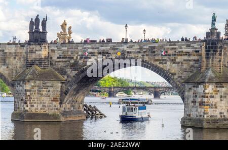Touristische Boot Adria vorbei unter gotischen Bögen der Karlsbrücke über die Moldau Brücke in Prag in der Tschechischen Republik. Stockfoto