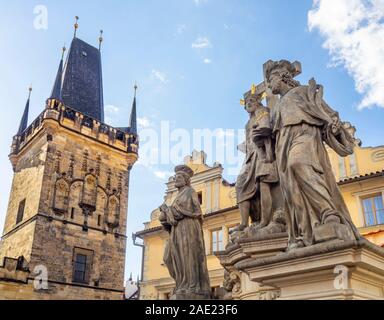 Replica Statuen der Heiligen Cosmas und Damian auf der Karlsbrücke und Altstädter Brückenturm in Prag in der Tschechischen Republik. Stockfoto