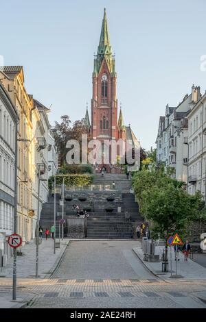 BERGEN, Norwegen - 19 Juli 2019: Menschen auf der Treppe zu Johanneskirk Kirche, unter hellen niedrigen Sommer Licht schoss am 19. Juli, 2019 in Bergen, Norwegen Stockfoto