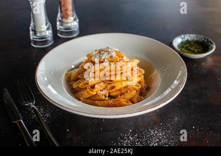 Italienischen Pasta. Nudeln mit Parmesan in Weiß Platte auf metallischen Hintergrund. Abendessen. Lauch. Ansicht von oben. Slow food Konzept Foto Stockfoto