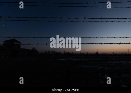 05 Dezember 2019, Polen, Oswiecim: Die Sonne hinter einem Stacheldrahtzaun im ehemaligen Konzentrationslager Auschwitz-Birkenau. Bundeskanzlerin Angela Merkel (CDU) wird die Gedenkstätte im ehemaligen deutschen Konzentrationslager für den ersten Besuch am 06.12.2019. Es ist somit die Annahme einer Einladung der Stiftung Auschwitz-Birkenau anlässlich seines 10-jährigen Bestehens. Foto: Robert Michael/dpa-Zentralbild/dpa Stockfoto