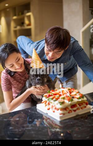 Junges Paar Hund feiert Geburtstag Stockfoto