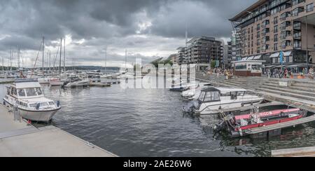 OSLO, Norwegen - 21. Juli 2019: zeitgenössische Architektur und angelegten Boote an Tjuvholmen Stadterneuerung neighborough, Schuß bei bewölktem hellen Sommer li Stockfoto