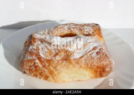 Frisch gebackenen Blätterteig mit Hüttenkäse. Europäisches Frühstück. Backen auf einer weißen Platte. Stockfoto