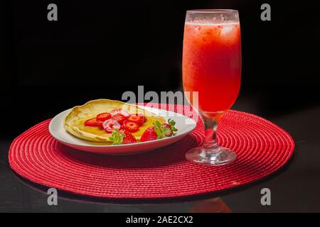 Hausgemachte Pfannkuchen mit Erdbeeren und Sirup in die weiße Schale. Stockfoto