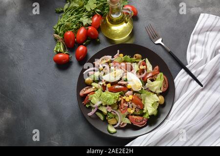 Thunfischsalat mit Salat, Eiern und Tomaten, Gurke, Mais und roter Zwiebel. Gesundes mediterranes Lebensmittelkonzept Stockfoto
