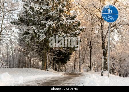 Ein Zeichen für die Trennung von Fußgänger- und Fahrradwegen mit Schnee bedeckt closeup im Winter. Die Bike Saison ist geschlossen. Stockfoto