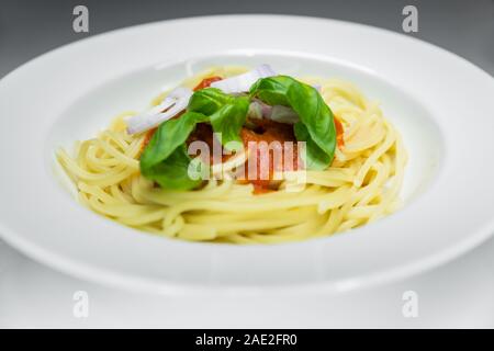 Spaghetti mit Tomatensauce pachino mit frischem Basilikum, ein typisches Gericht in Süditalien. Die pachino Tomate stammt aus Sizilien. Stockfoto