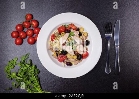 Spaghetti mit Thunfisch, Kapern, Oliven, sizilianischen Chili, Kirschtomaten und einer Prise Petersilie Stockfoto