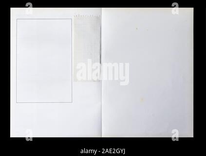 White Book aufgeklappt angezeigt werden leere Seiten mit einem Rahmen und einem Stück Papier auf einem schwarzen Hintergrund. Stockfoto
