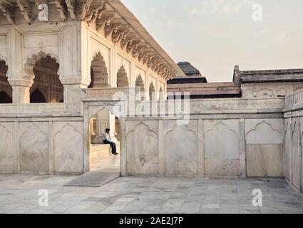 AGRA, Uttar Pradesh, Indien - 25. Februar 2015: ein Porträt von einem Wachmann sitzt hinter dem Eingang der alten Agra Fort gebaut von der Mugha Stockfoto