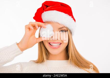 Freundliche hübsche Mädchen hat ihr Auge durch Santa's Hut pompon geschlossen Stockfoto