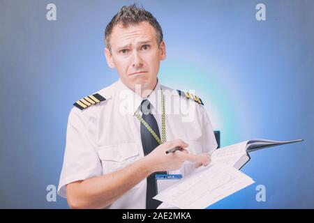 Airline Pilot tragen Shirt mit Schulterklappen und Riegel ausfüllen Füllen und Kontrolle der Papiere Logbuch und Prüfung der Papiere und Wettervorhersage Stockfoto