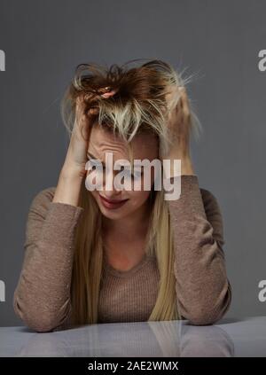 Frau, die unter Stress leiden oder Kopfschmerzen während durch Schmerz beleidigt wird, Stockfoto