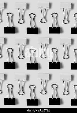 Schwarze und weiße binder clips sauber über weißen Hintergrund organisiert, Ansicht von oben Stockfoto