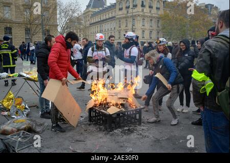 PARIS, Frankreich, 05. Dezember 2019: Demonstranten und Straße Mediziner brennen Kartons selbst während einer 'Gilets Jaunes' (Gelb) Protest zu warm. Stockfoto