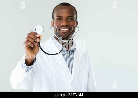 Positive professionelle Arzt mit seinem Stethoskop Stockfoto