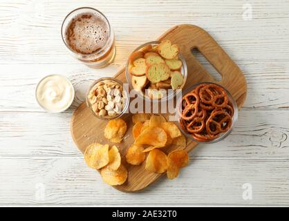 Chips, Bier, Bier, Snacks, Bier, Muttern, Saucen auf weißem Hintergrund Holz, Platz für Text. Ansicht von oben Stockfoto