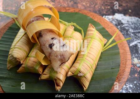 Lepet, Javanische, Indonesische Küche Nachtisch. Klebriger Reis Knödel mit schwarzen Bohnen in Kokosmilch gekocht in jungen Coconut leaf gewickelt Stockfoto