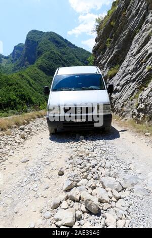 Theth, Albanien, 6. Juli 2019: Camping Bus auf einem Feldweg in der Landschaft mit grünen Wäldern im nördlichen Dinarischen Alpen in Albanien Stockfoto