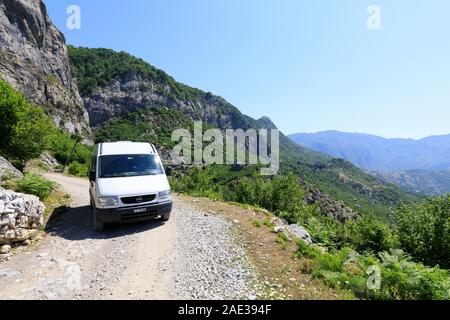 Theth, Albanien, 6. Juli 2019: Camping Bus auf einem Feldweg in der Landschaft mit grünen Wäldern im nördlichen Dinarischen Alpen in Albanien Stockfoto