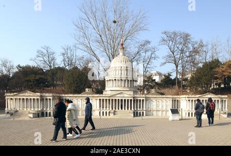 Peking, China. 06 Dez, 2019. Chinesische Touristen vorbei an einer kleinen Capitol Gebäude, die in der nordamerikanischen Abschnitt des World Park in Peking am Freitag, 6. Dezember 2019. China am Freitag sagte, er hatte Sie ciprocal" Maßnahmen gegen den US-Diplomaten in China, bestellen Sie das Auswärtige Amt vor dem Treffen mit lokalen Beamten - ein "Gegenmaßnahme" zu Washingtons Entscheidung im Oktober chinesische Diplomaten zu beschränken, zu benachrichtigen. Foto von Stephen Rasierer/UPI Quelle: UPI/Alamy leben Nachrichten Stockfoto