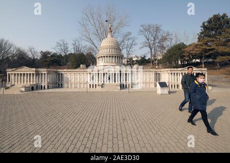 Peking, China. 06 Dez, 2019. Chinesische Touristen vorbei an einer kleinen Capitol Gebäude, die in der nordamerikanischen Abschnitt des World Park in Peking am Freitag, 6. Dezember 2019. China am Freitag sagte, er hatte Sie ciprocal" Maßnahmen gegen den US-Diplomaten in China, bestellen Sie das Auswärtige Amt vor dem Treffen mit lokalen Beamten - ein "Gegenmaßnahme" zu Washingtons Entscheidung im Oktober chinesische Diplomaten zu beschränken, zu benachrichtigen. Foto von Stephen Rasierer/UPI Quelle: UPI/Alamy leben Nachrichten Stockfoto