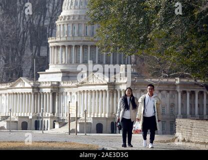 Peking, China. 06 Dez, 2019. Chinesische Touristen vorbei an einer kleinen Capitol Gebäude, die in der nordamerikanischen Abschnitt des World Park in Peking am Freitag, 6. Dezember 2019. China am Freitag sagte, er hatte Sie ciprocal" Maßnahmen gegen den US-Diplomaten in China, bestellen Sie das Auswärtige Amt vor dem Treffen mit lokalen Beamten - ein "Gegenmaßnahme" zu Washingtons Entscheidung im Oktober chinesische Diplomaten zu beschränken, zu benachrichtigen. Foto von Stephen Rasierer/UPI Quelle: UPI/Alamy leben Nachrichten Stockfoto