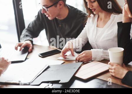 Kerl mit Laptop. Junge Studenten, die auf dem Projekt arbeiten beim Sitzen im Zimmer in der Nähe der Fenster Stockfoto