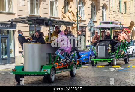 Männliche Touristen eine Party trinken Ale oder Bier auf ein Bier Bike durch die Straßen von Prag in der Tschechischen Republik. Stockfoto