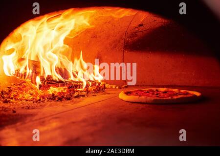Prozess des Kochens. Feuer im Ofen. Nahaufnahme von Holz in Flammen Stockfoto