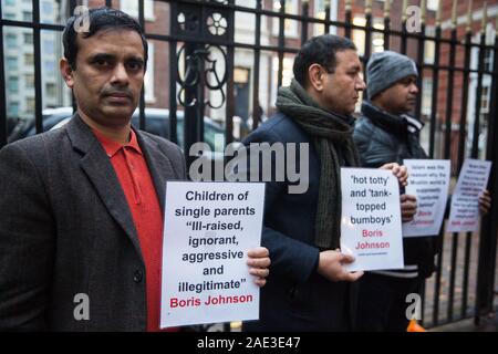 London, Großbritannien. 6. Dezember, 2019. Eine kleine Gruppe von Aktivisten Plakate Hervorhebung Beleidigende Bezeichnungen und Beschreibungen, die in der Vergangenheit von Premierminister Boris Johnson verwendet Proteste vor dem Sitz der Konservativen Partei. Credit: Mark Kerrison/Alamy leben Nachrichten Stockfoto