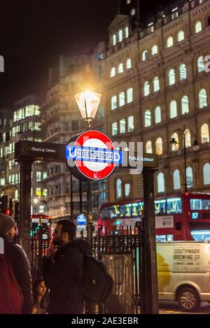 U-Bahn-Schild in London an der U-Bahn-Treppe, Eingang zur Charing Cross Station am Trafalgar Square, im Zentrum von London, Großbritannien, nachts mit Straßenbeleuchtung beleuchtet. Stockfoto