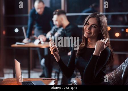 Positive Frau. Team der jungen Unternehmer arbeitet an ihrem Projekt in der Nacht im Büro Stockfoto