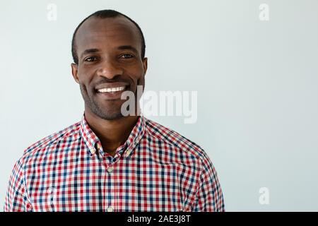 Portrait von lächelnden afro-amerikanische Mann stand vor weißem Hintergrund Stockfoto