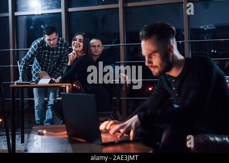 Konzentrierte sich auf die Freunde hinter sich. Team der jungen Unternehmer arbeitet an ihrem Projekt in der Nacht im Büro Stockfoto