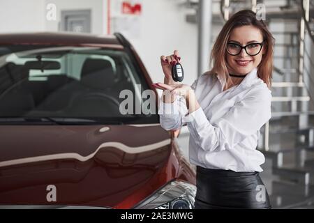 Hübsches Mädchen. Frau in Brillen und weißes Hemd steht in der Nähe der roten Automobil Stockfoto