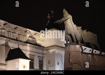 Gediminas statue am Cathedral Square in Vilnius mit Palast der Großfürsten von Litauen über Hintergrund, Nacht Stockfoto